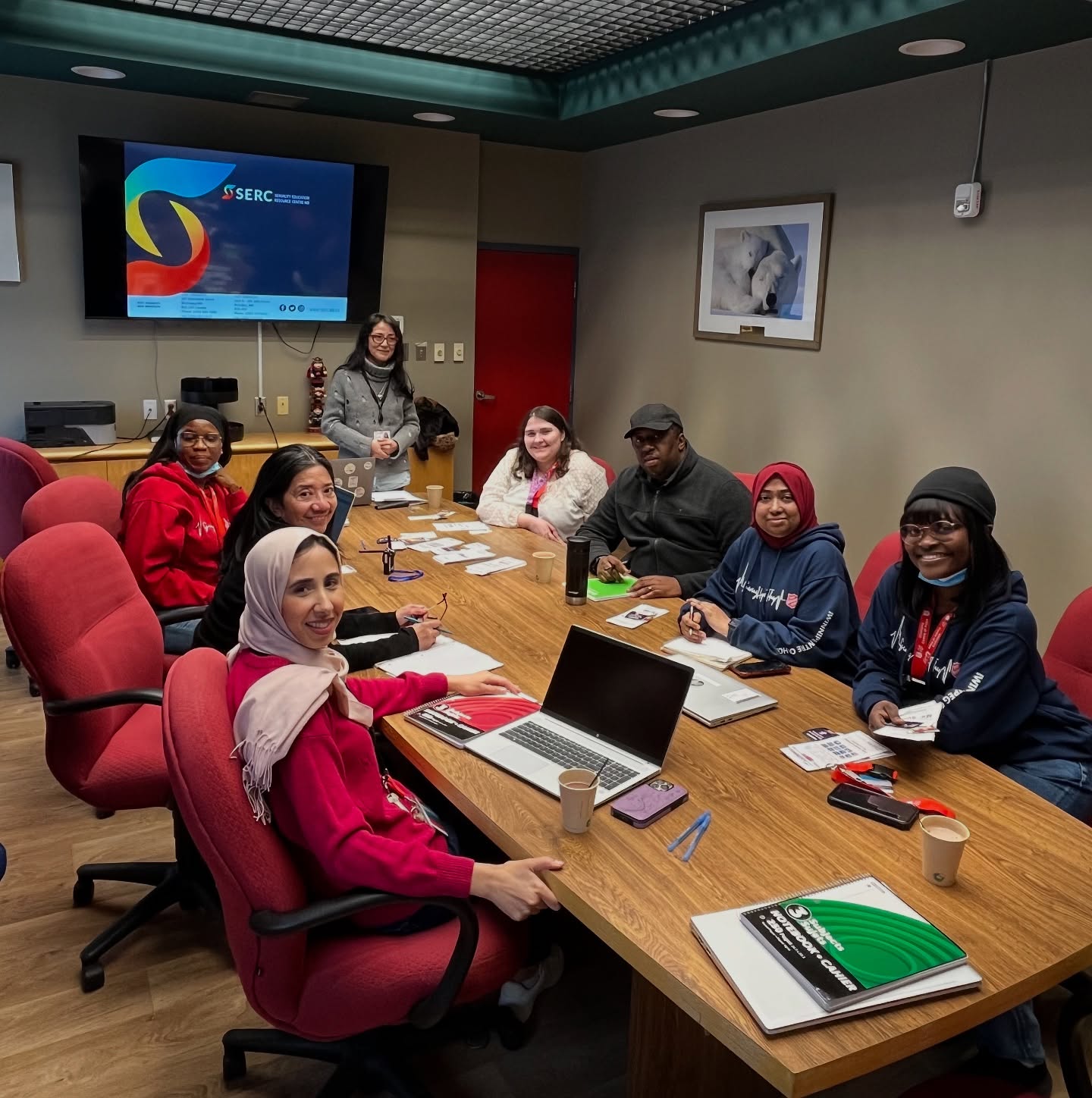 a group of case managers at WCOH seated in a round table with their laptops and writing instruments