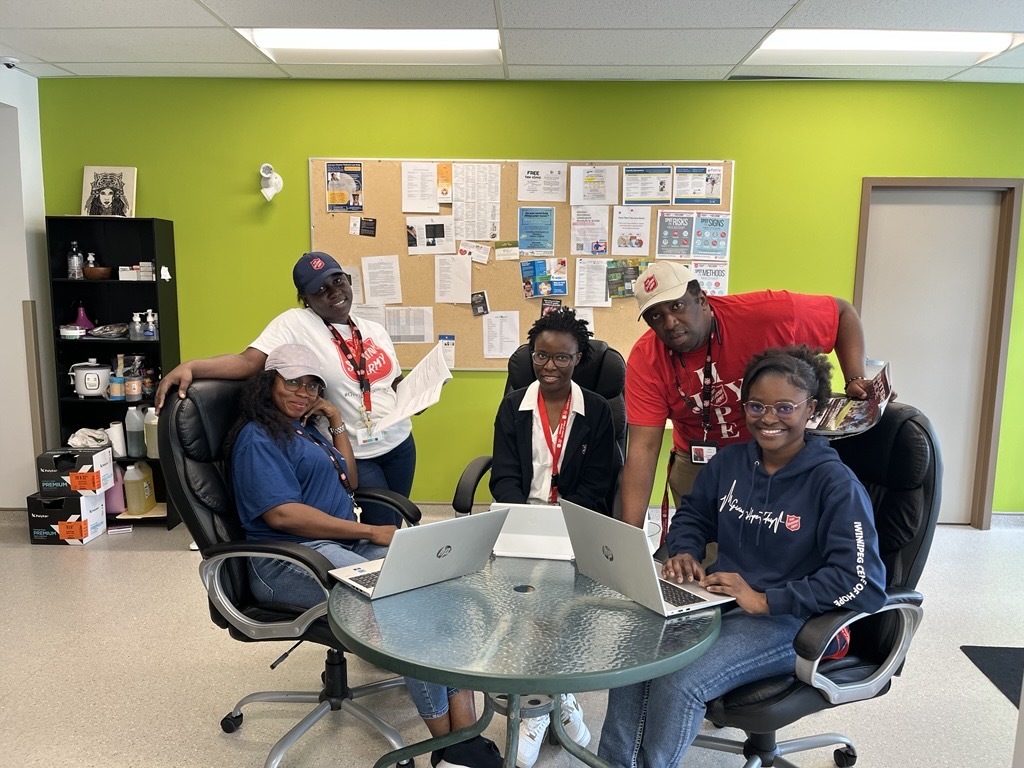 Group of case workers, 4 female and 1 male seated with their laptops