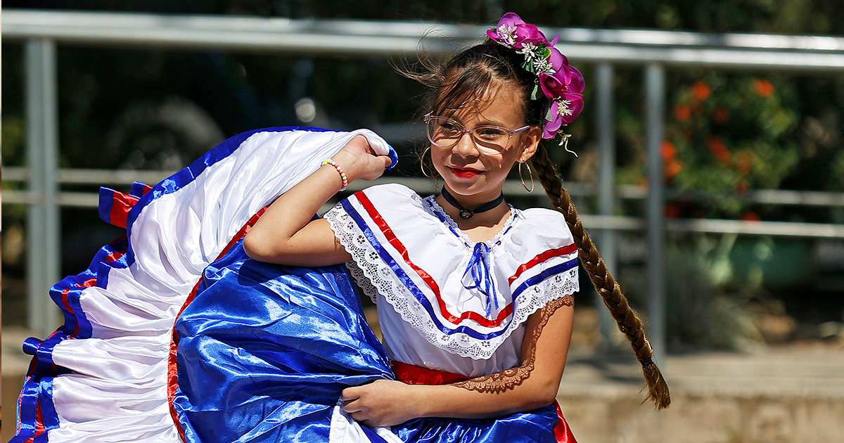 A girl dancing in a white, blue and red dress