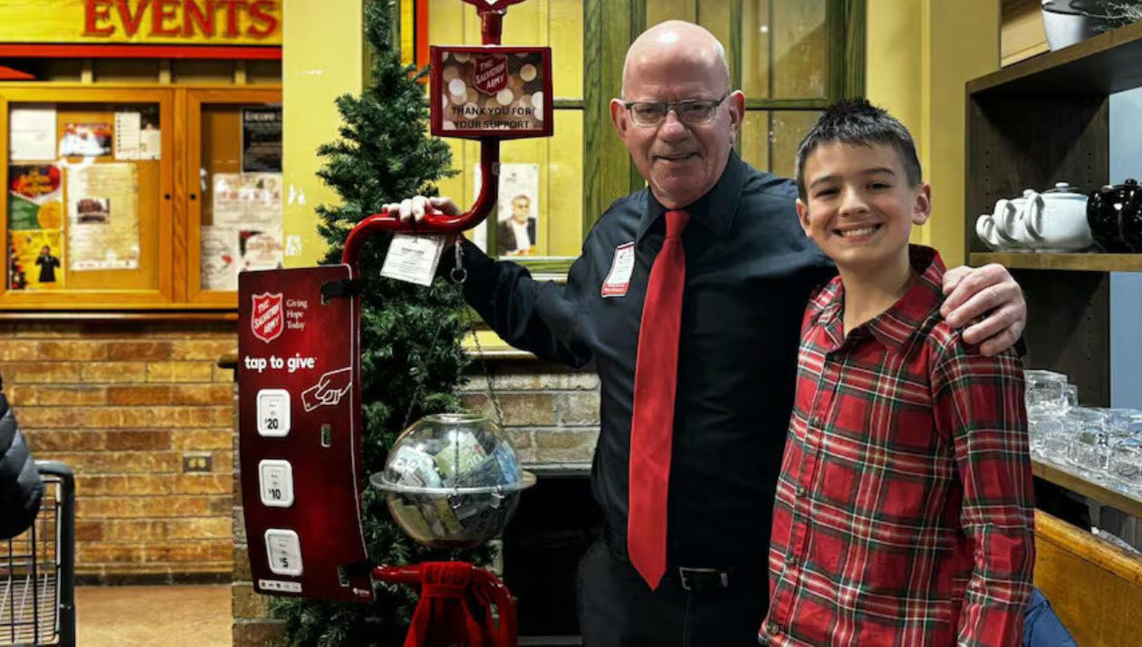 Grandfather standing with grandson at Christmas Kettle.